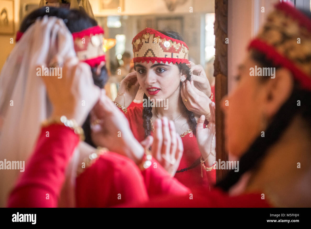 Jeune danseuse arménienne à miroir dans un autre jeune comme danseuse permet d'ajuster son voile,Washington Heights, Maryland. Banque D'Images