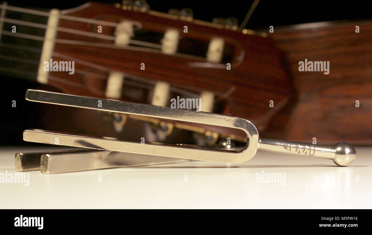 Diapason, deux fourches en acier avec des guitares classiques cordes  derrière avec touches de réglage, la machine, chefs et visible de la tête  Photo Stock - Alamy