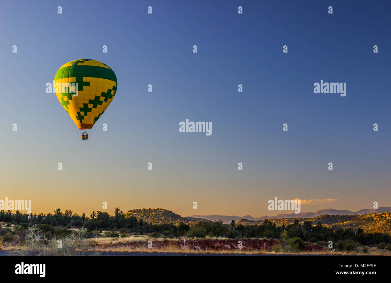 Vert et Jaune Montgolfière sur High Desert au lever du soleil Banque D'Images