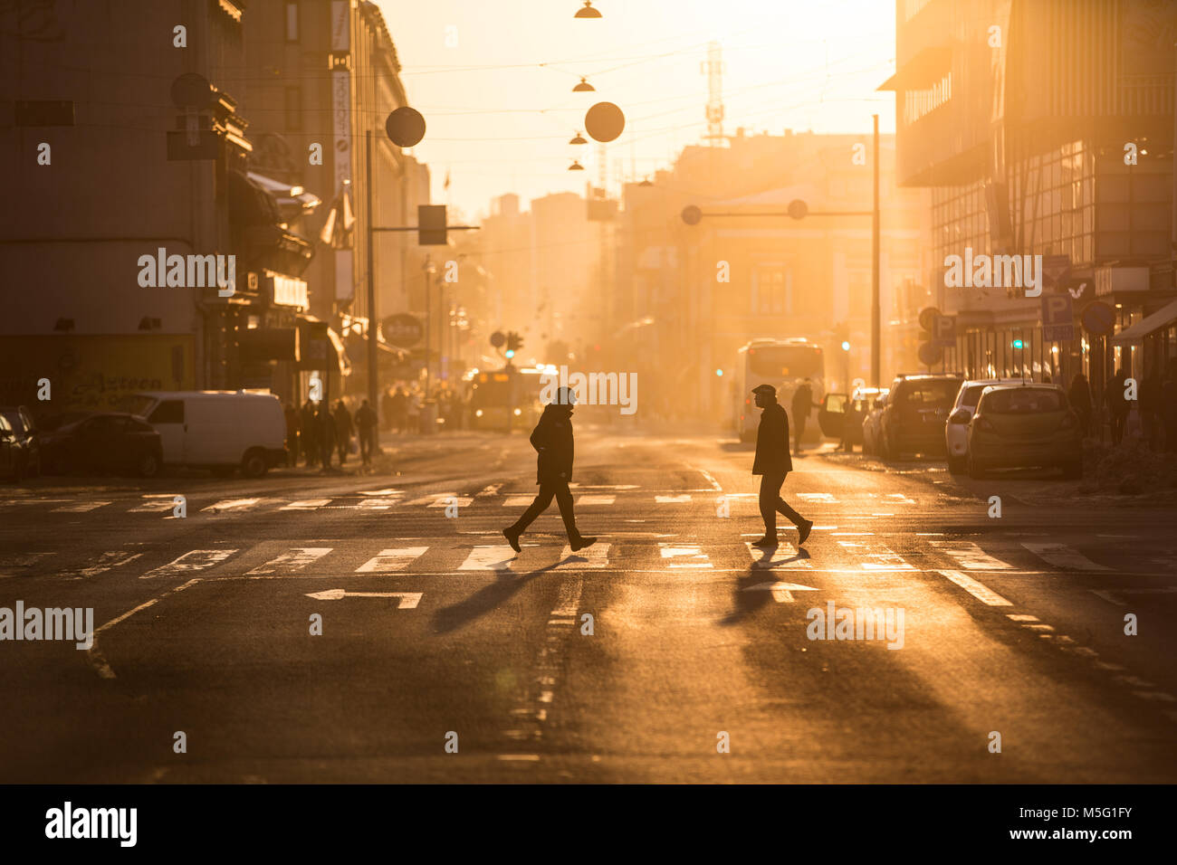 Paris, France - 19 février 2018 - Les personnes qui traversent la rue pendant le coucher du soleil d'or dans le centre de Turku. Banque D'Images