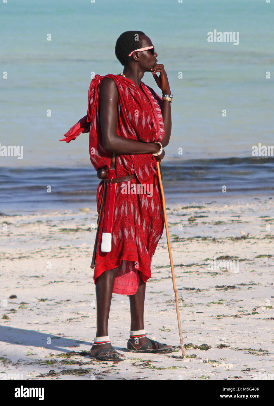 Les Massaïs man standing on the beach, plage de Nungwi, Zanzibar, Tanzanie Banque D'Images