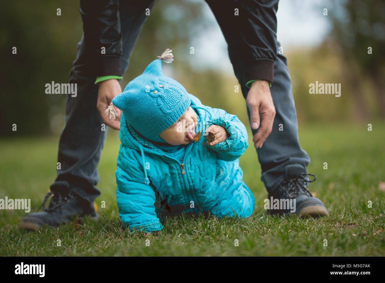 Happy Family walking in autumn park : l'enfant essaie de goût qui peut ne pas essayer Banque D'Images