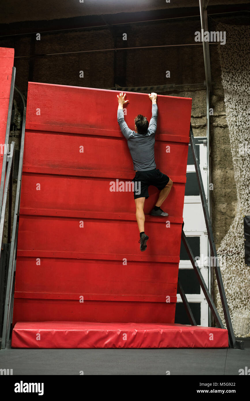 L'homme pratiquant l'escalade sur un mur Banque D'Images