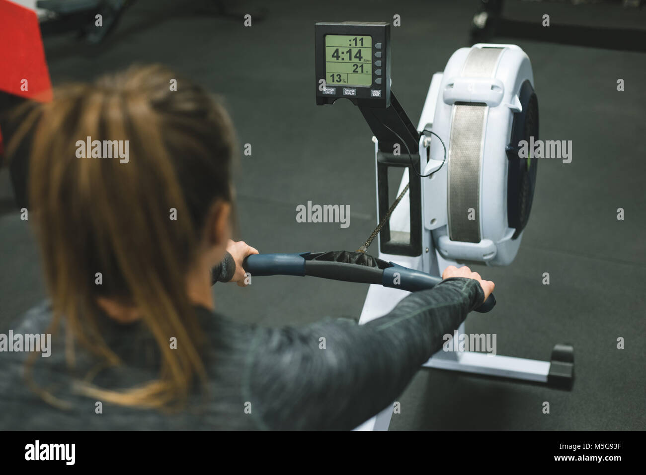 La femme l'exercice sur machine à ramer Banque D'Images