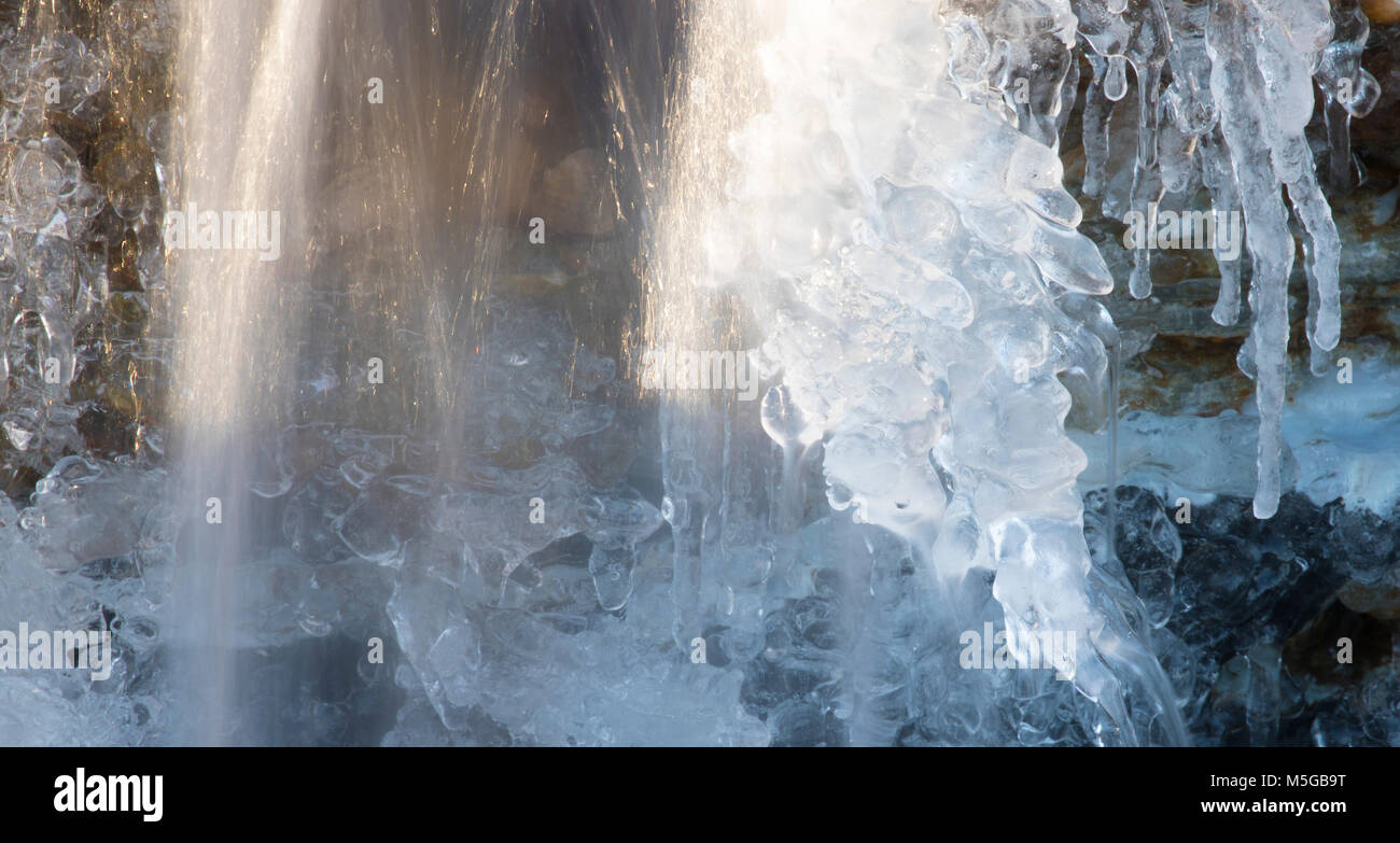 La formation de glace sur le visage d'une petite cascade avec de l'eau circule toujours Banque D'Images