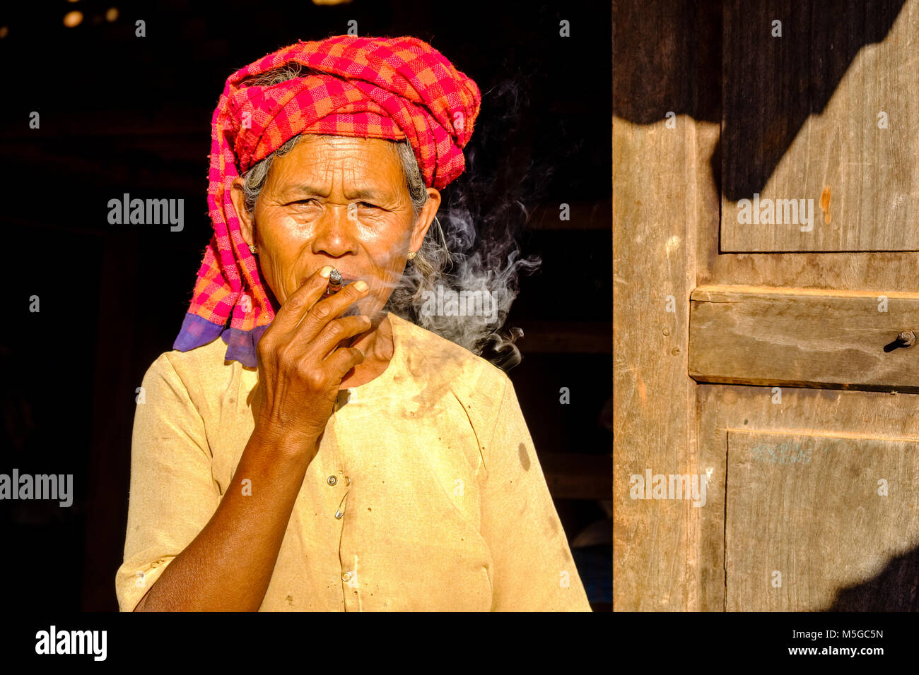Portrait d'une femme qui fume un Cheerot agriculteurs, un cigare, dans un village dans les collines de la région tribale Banque D'Images