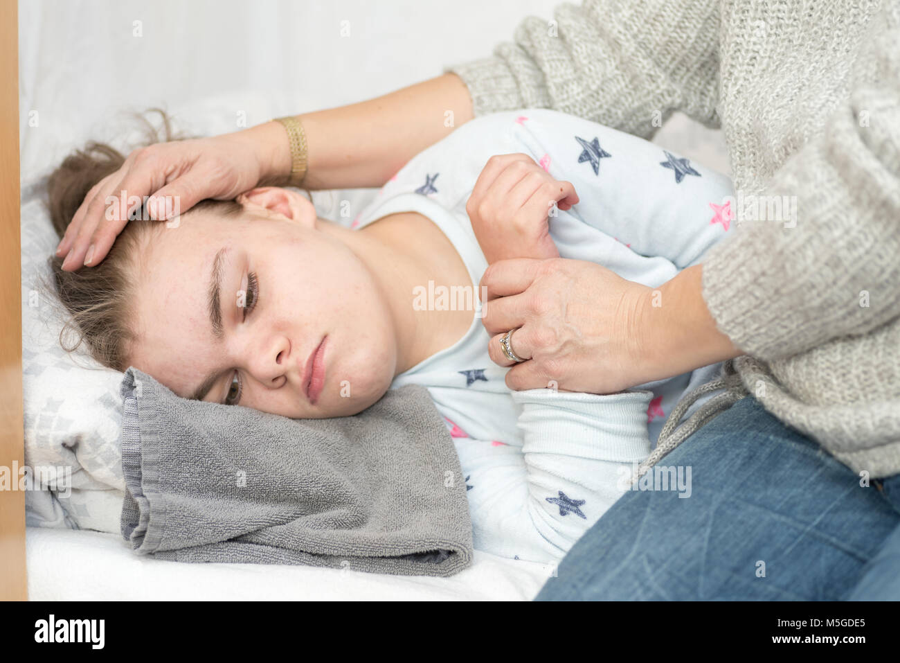 Un enfant épileptique durant une crise qui sont pris en charge par un soignant qualifié. Banque D'Images