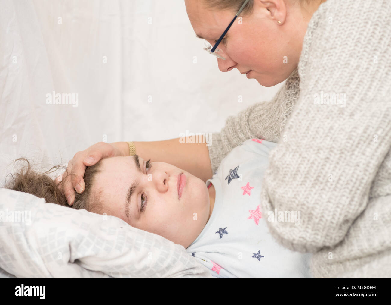 Un enfant épileptique durant une crise qui sont pris en charge par un soignant qualifié. Banque D'Images