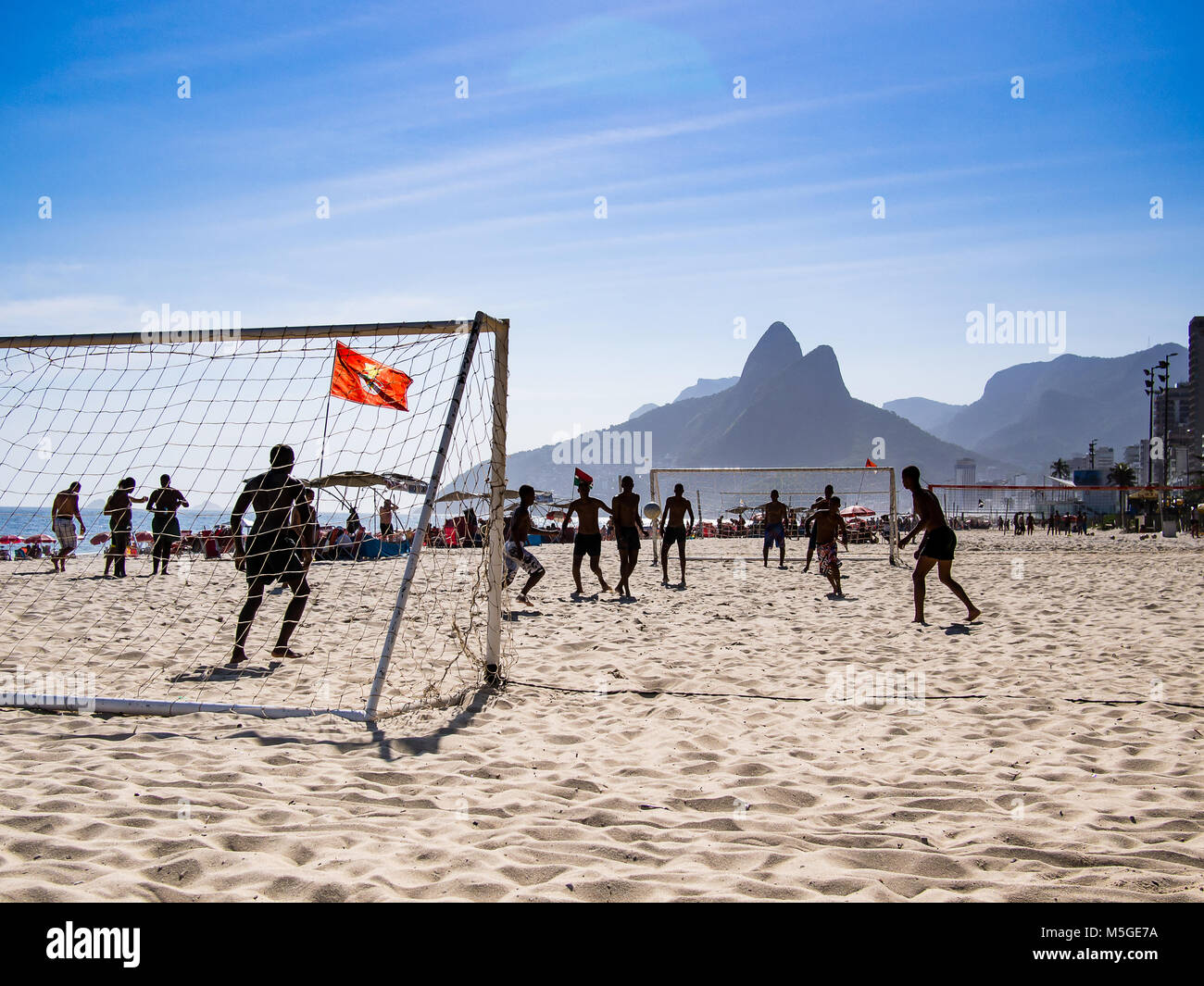 Les garçons jouent au soccer sur une journée ensoleillée à la plage d'Ipanema, Rio de Janeiro Banque D'Images