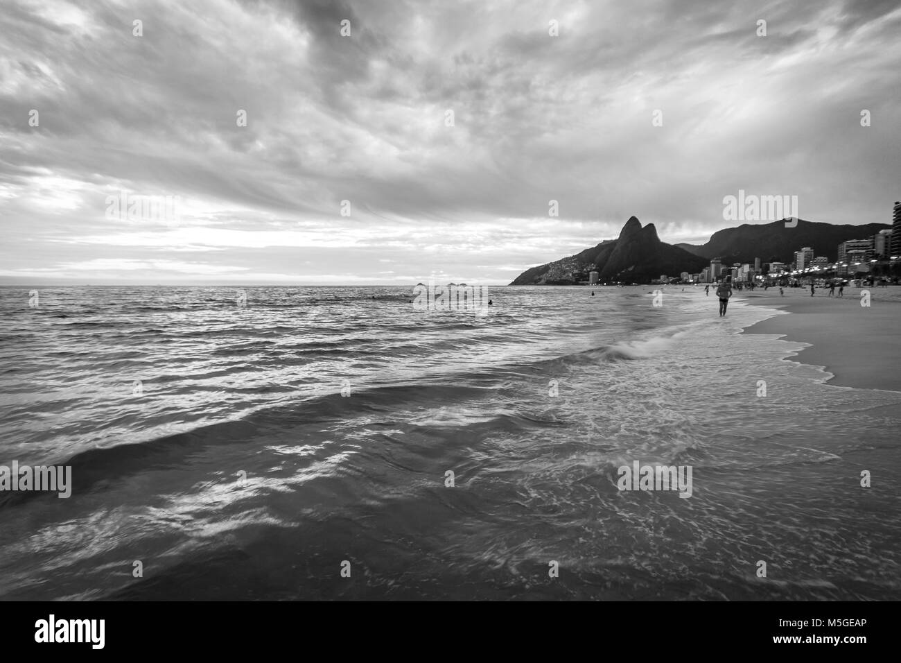 La plage d'Ipanema pendant le coucher du soleil, un ciel orageux, longue exposition, noir et blanc Banque D'Images
