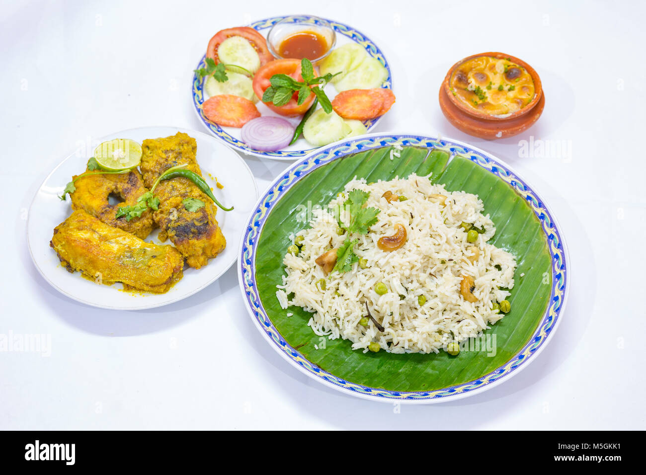 Populaires de délicieux repas de cuisine indienne Bengali avec riz frit aux légumes , épicé curry de poisson, des salades et un plat sucré. Banque D'Images