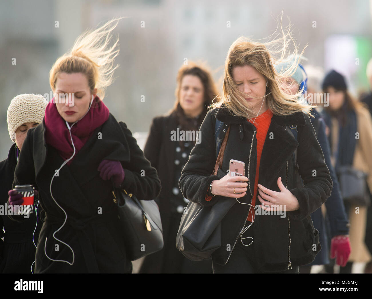 Les gens en manteaux d'hiver et des foulards de Waterloo Bridge, dans le centre de Londres, que le gel de l'air La Russie est à serrer le UK dans ce qui est défini pour être le plus froid de la fin de février à cinq ans. Banque D'Images