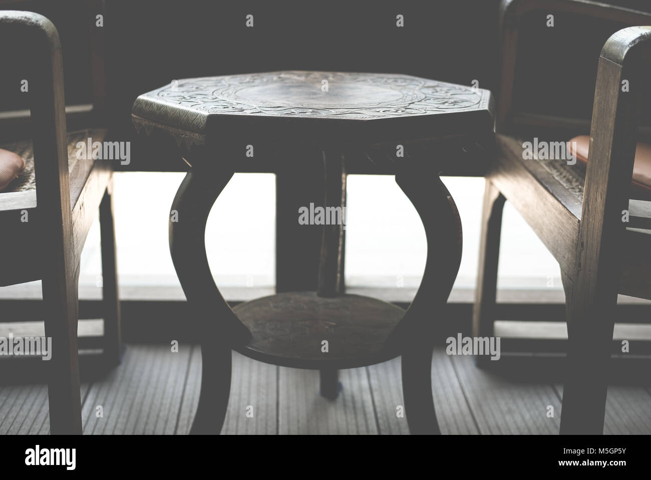 Table en bois octogonal et une chaise dans la salle de séjour près de fenêtre dans chambre Banque D'Images