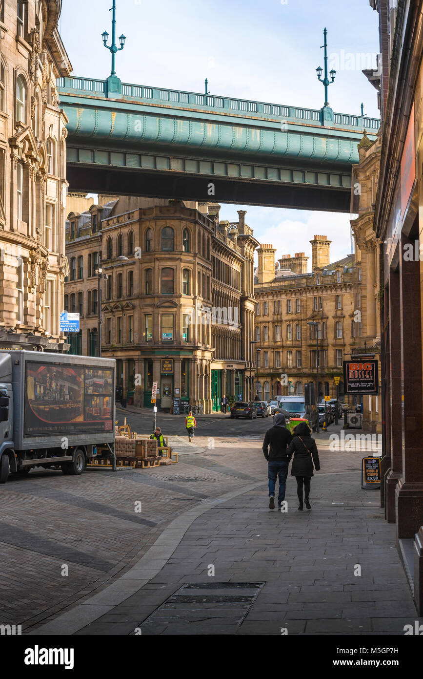 Un jeune couple à pied vers le pont Tyne dans la vieille ville quayside de côte dans la ville de Newcastle Upon Tyne, Tyne and Wear, England, UK Banque D'Images