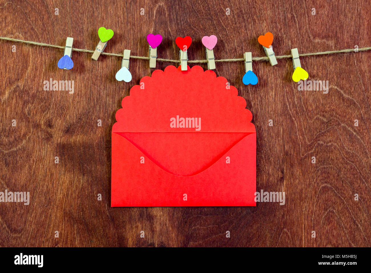 Les mains des femmes sortir une lettre d'une enveloppe rouge. Le jour de la Saint-Valentin. L'amour, les relations. Banque D'Images