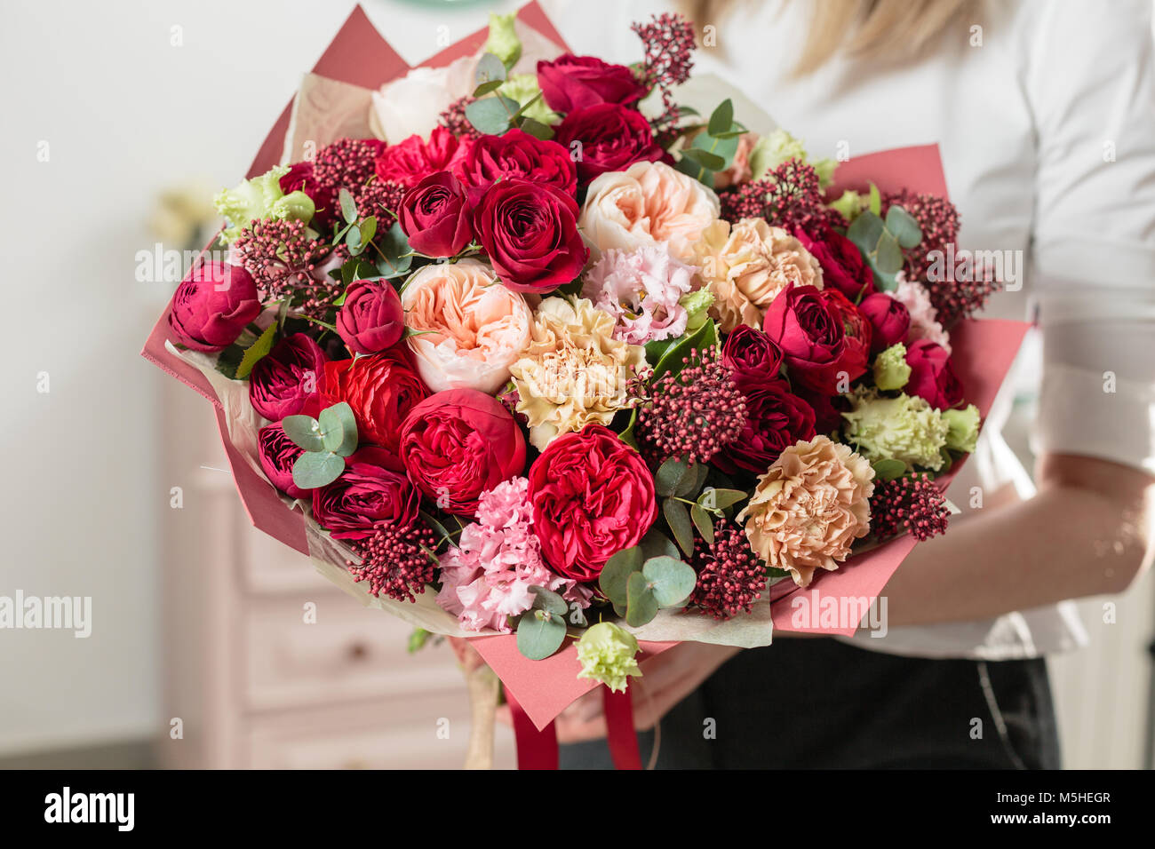 Bouquet de couleur rouge très . beau bouquet de fleurs mixtes de luxe en  main de womans. le travail de la fleuriste à un magasin de fleur Photo  Stock - Alamy