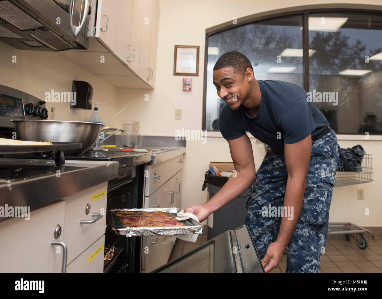 KINGS BAY, Ga. (fév. 13, 2018) - Spécialiste du Programme Religieux 2e classe George Neal prépare le bacon à Kings Bay Chapelle's Mardi Gras Petit-déjeuner à bord Naval Submarine Base Kings Bay. Mardi Gras est un événement célébré dans certains pays en consommant des crêpes le mardi précédant le mercredi des Cendres (le premier jour du carême). (U.S. Navy Banque D'Images