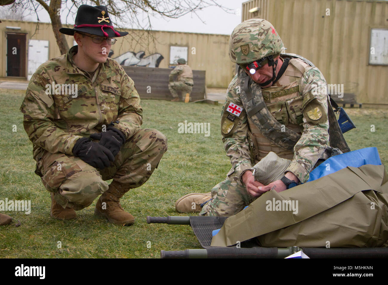 La CPS. Wesley Hobson, un infirmier affecté à l'Escadron, 2d 4ème régiment de cavalerie, observe un soldat du 11e Bataillon d'infanterie légère, 1re Brigade d'infanterie, les Forces terrestres géorgiennes, placer un pansement sur une victime simulée au cours d'un Combat Life Saver 9 Février 2018 Bien sûr, au centre de formation de simulation médicale dans la zone d'entraînement Grafenwoehr, Allemagne. Les soldats géorgiens sont la formation avec U.S. Marine Corpsmen pour un prochain déploiement en Afghanistan. Les soldats ont chargé le cours sont à partir de la 2e et 7e régiment de cavalerie de la commande d'entraînement de l'armée. ( Banque D'Images