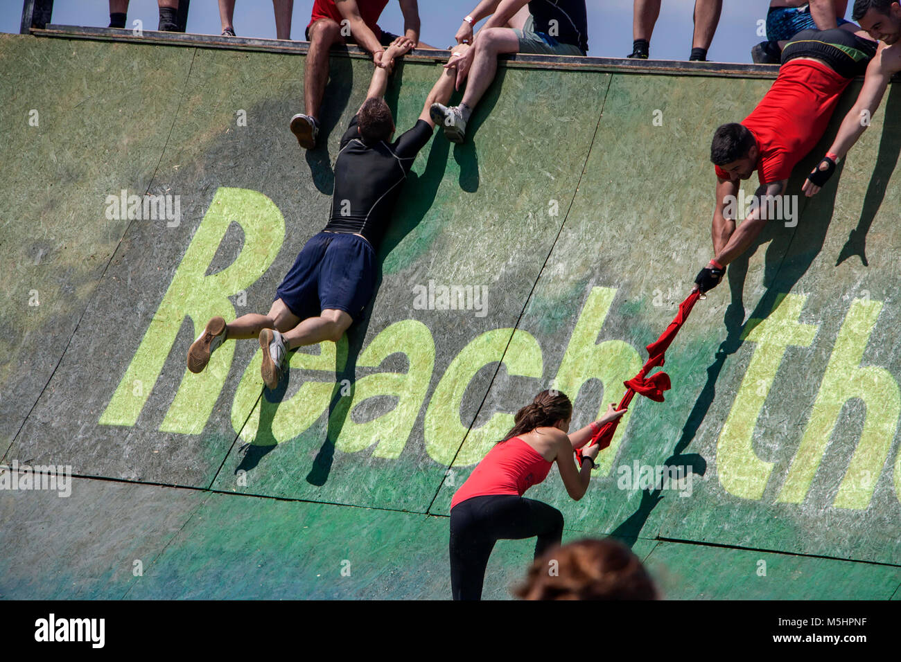 Les hommes sont en déplaçant leurs coéquipiers pour les aider à monter un mur au cours de la force de la Légion de course courir tenue à Sofia, Bulgarie le 26 juillet 2014 Banque D'Images