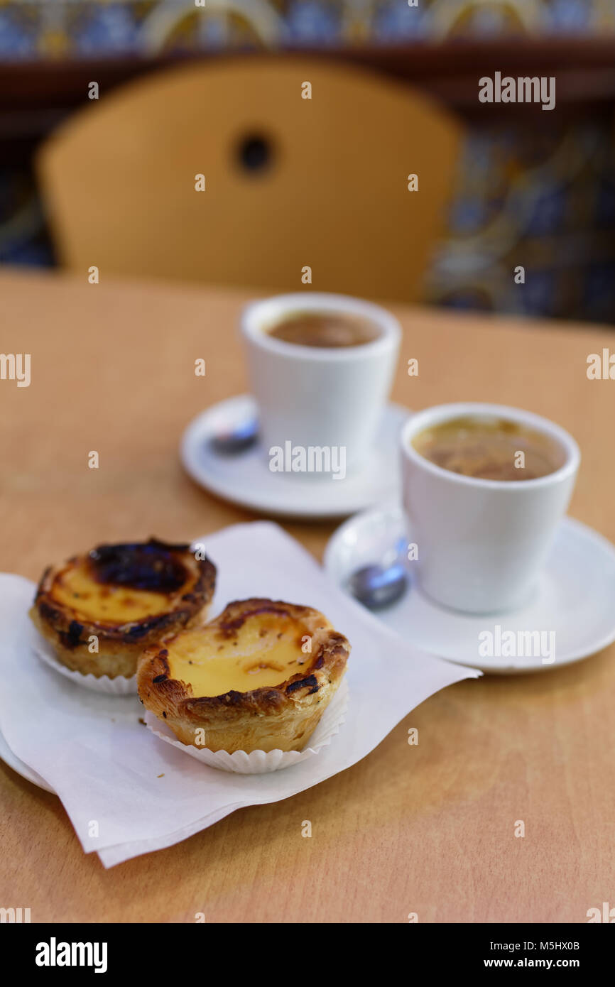 Tarte feuilletée oeuf portugais pastel de nata sur une plaque avec une tasse de café noir Banque D'Images