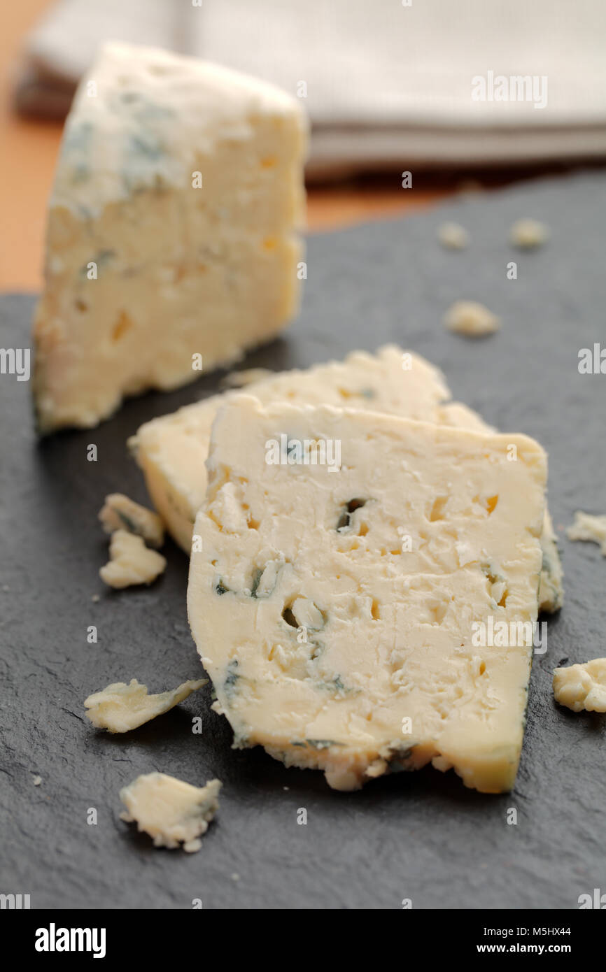 Tranches de fromage bleu sur une planche à découper ardoise Banque D'Images