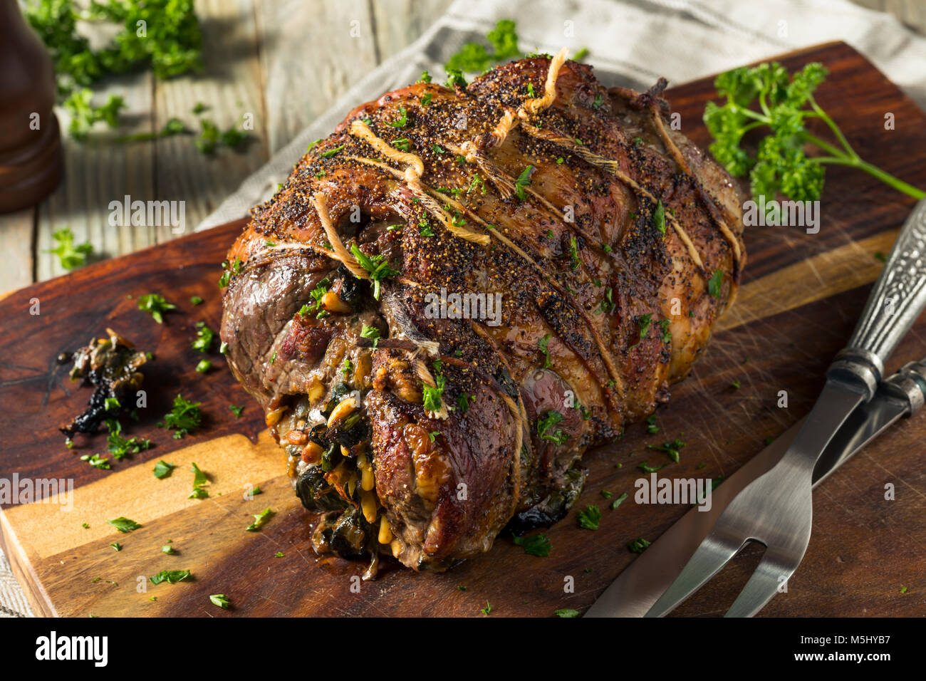 Gigot d'agneau rôti, farci aux épinards et noix de pin Banque D'Images