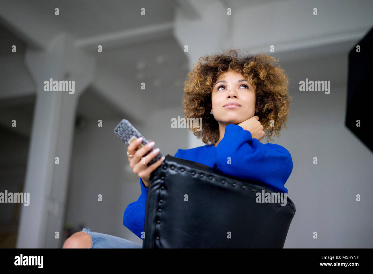Portrait of woman with cell phone assis sur un fauteuil Banque D'Images Portrait of woman with cell phone assis sur un fauteuil Banque D'Images