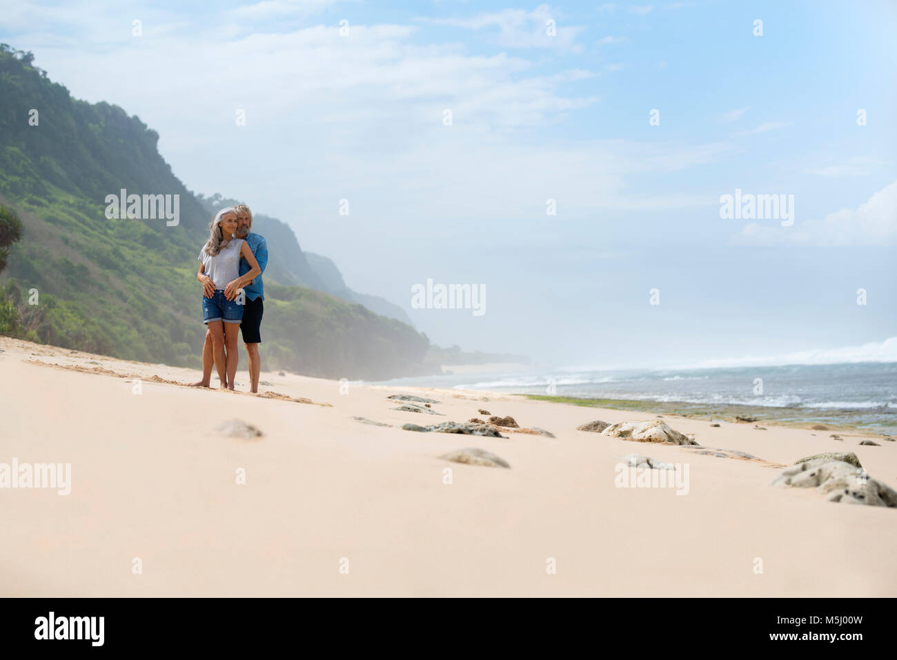 Romantic couple standing on the beach Banque D'Images