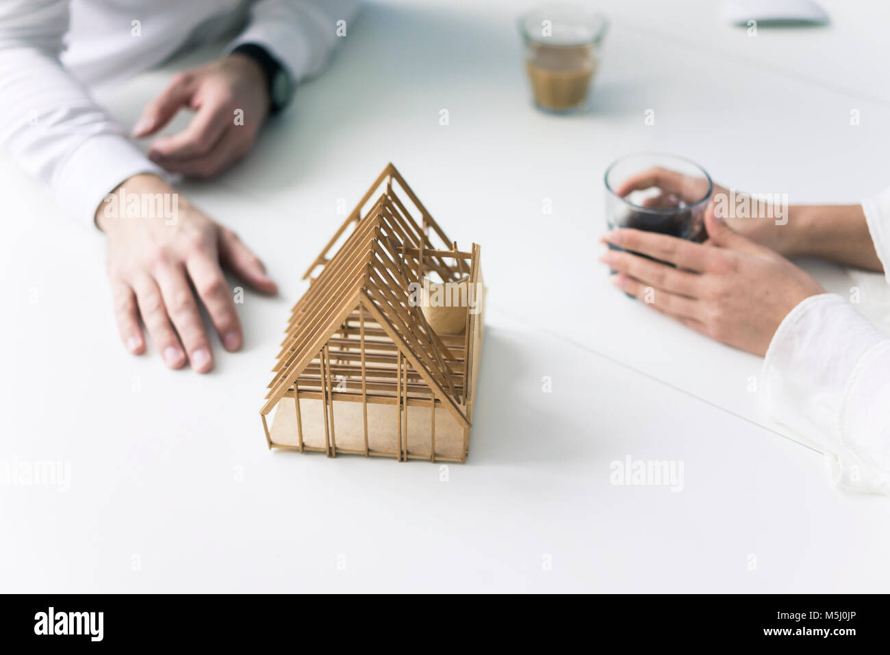 Les mains de l'homme et de la femme et de l'architecture modèle sur le tableau Banque D'Images