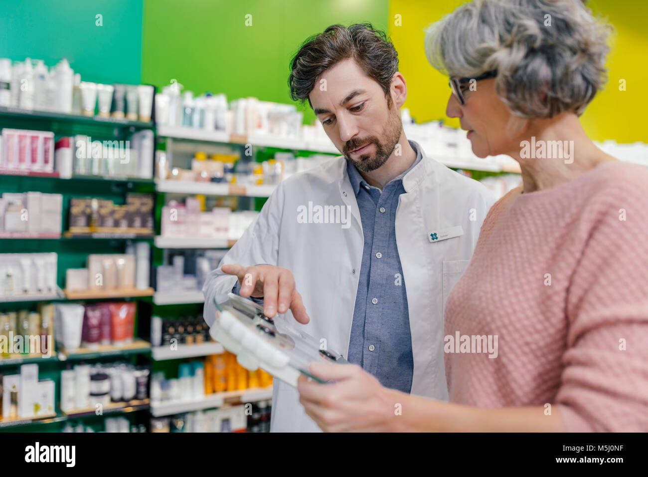 Pharmacien conseiller client avec sclaes in pharmacy Banque D'Images