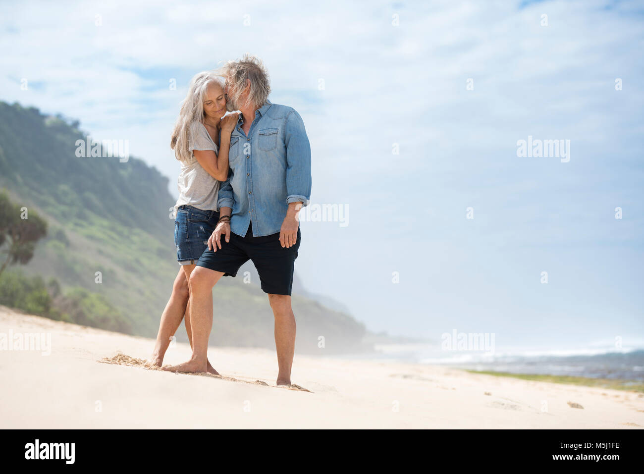 Romantic couple standing on the beach Banque D'Images