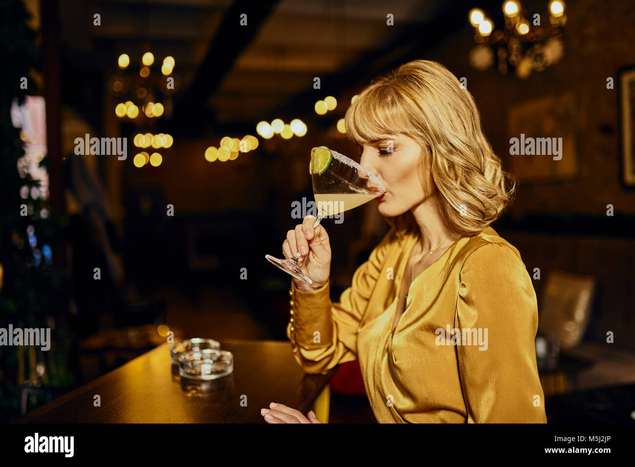 Elegant woman drinking cocktail dans un bar Banque D'Images