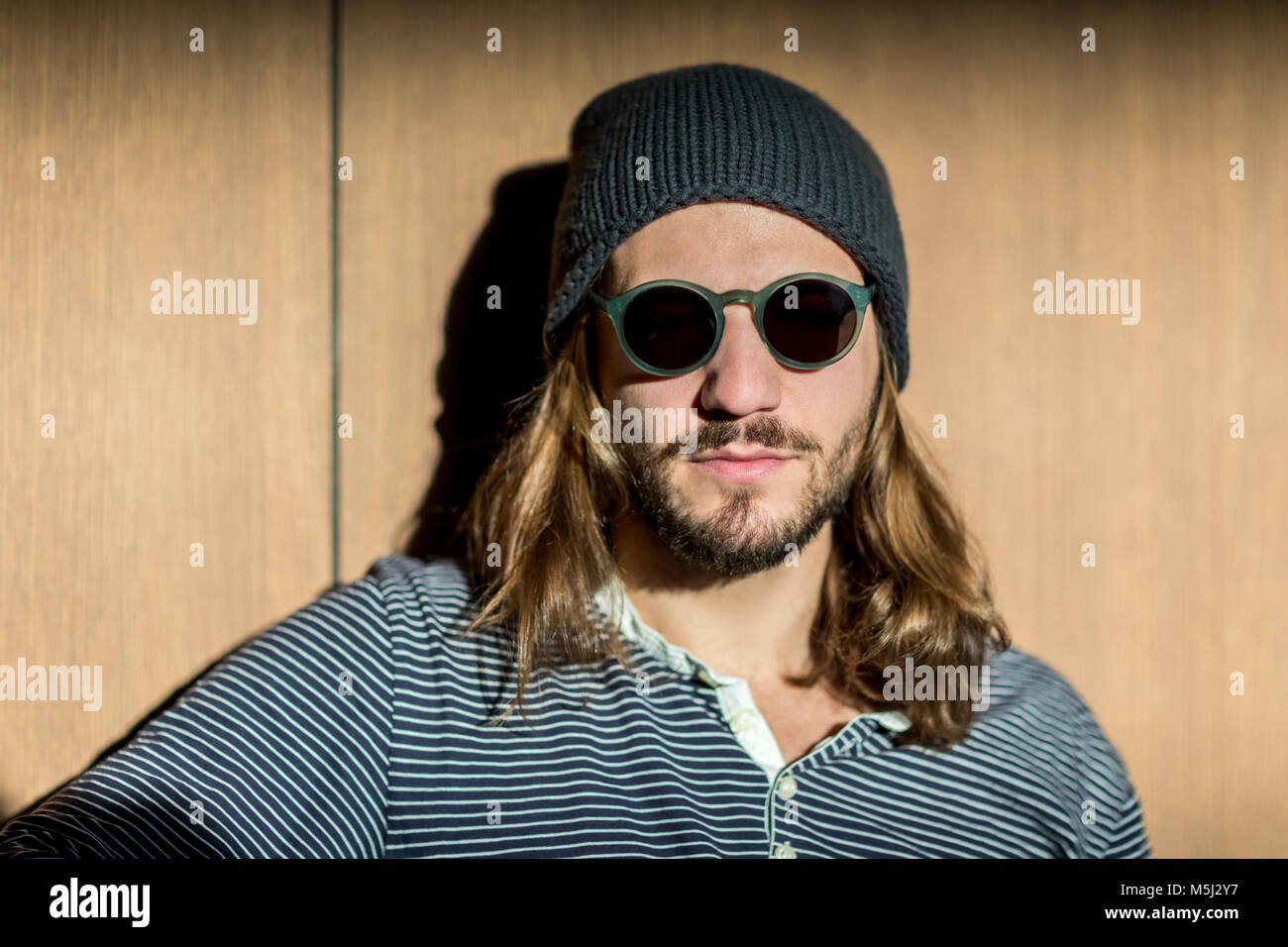 Portrait d'homme barbu aux cheveux longs portant des lunettes de soleil et  chapeau laineux Photo Stock - Alamy