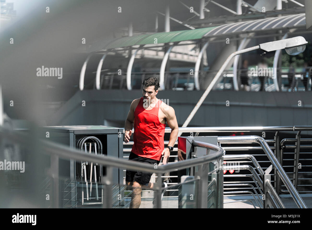 Runner Fitness shirt rouge en tournant sur le pont moderne Banque D'Images