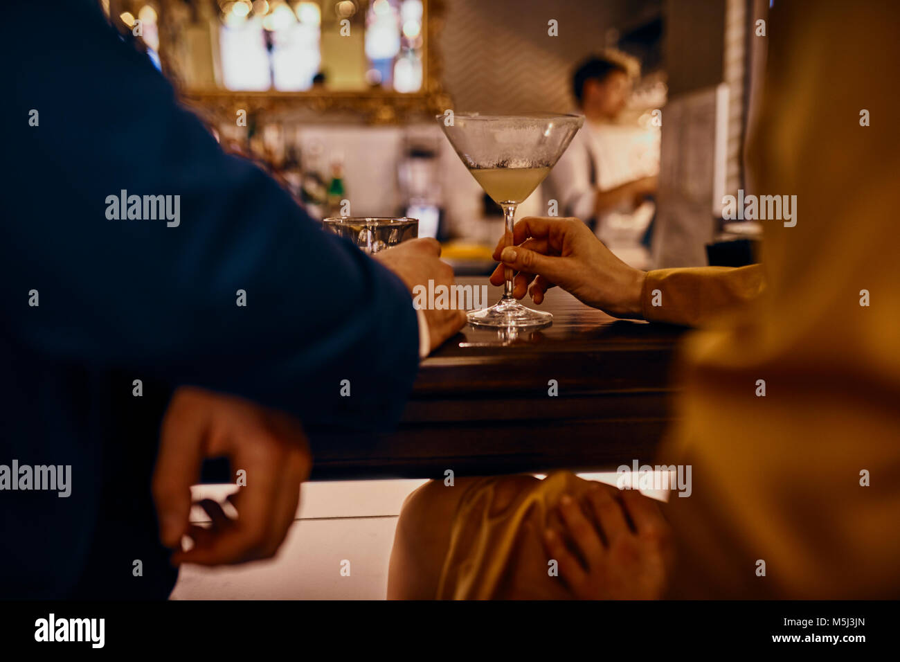 Close-up of elegant couple avoir un verre au comptoir d'un bar Banque D'Images