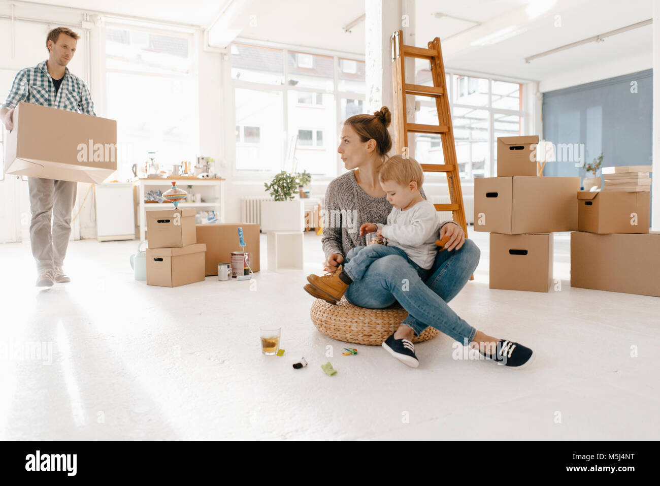 Déménagement de la famille dans la nouvelle maison avec père carrying cardboard box Banque D'Images