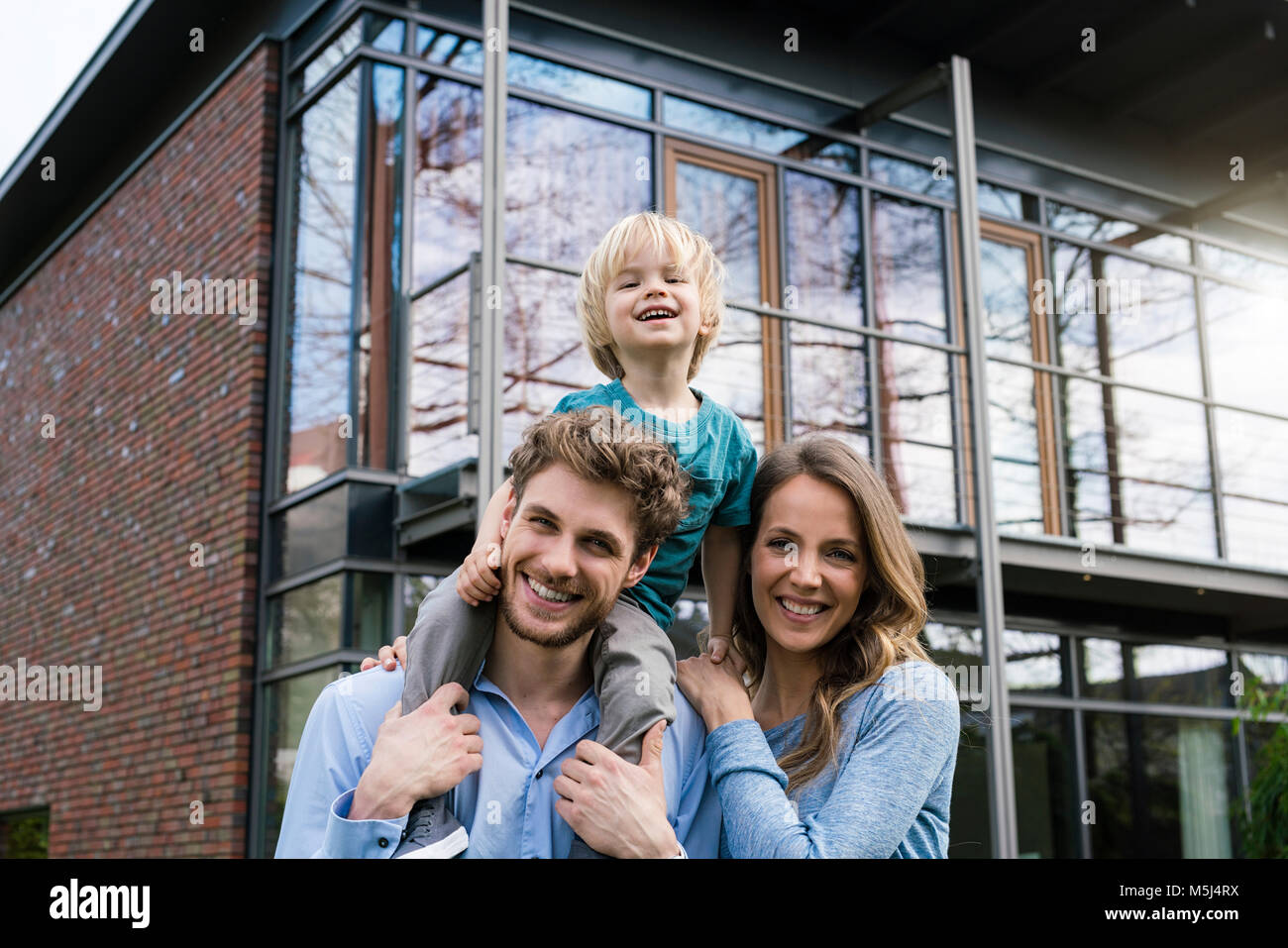 Portrait of smiling parents avec fils devant leur maison Banque D'Images