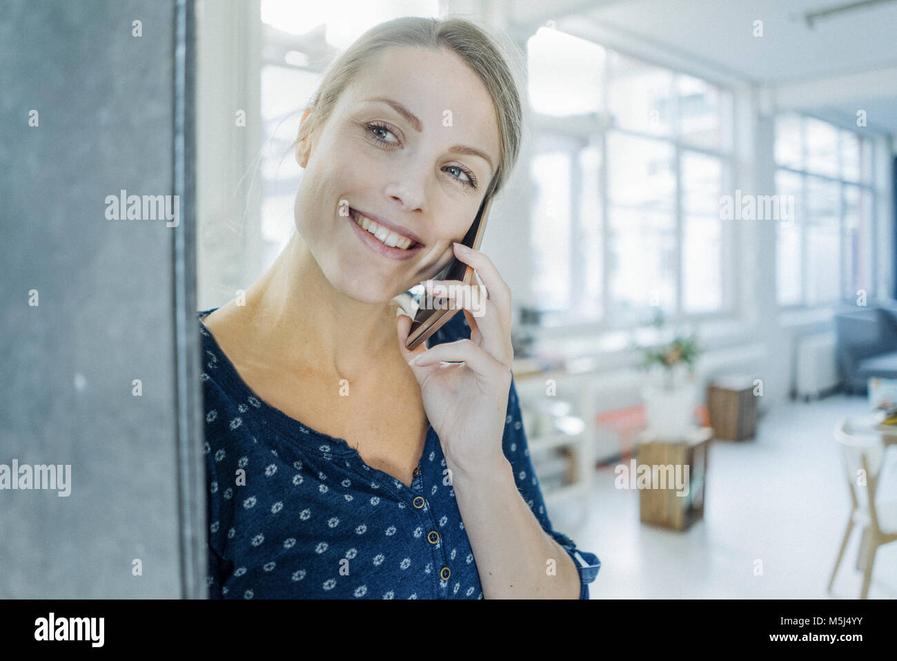 Portrait de jeune femme au téléphone dans un loft Banque D'Images