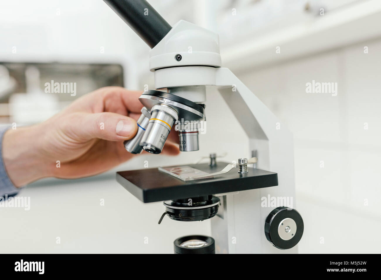 Close-up of laboratory technician using microscope in lab Banque D'Images