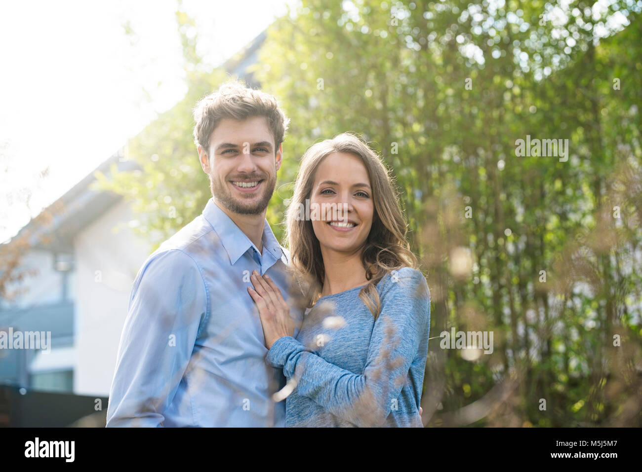 Portrait of smiling couple dans un jardin en face de plantes de bambou Banque D'Images