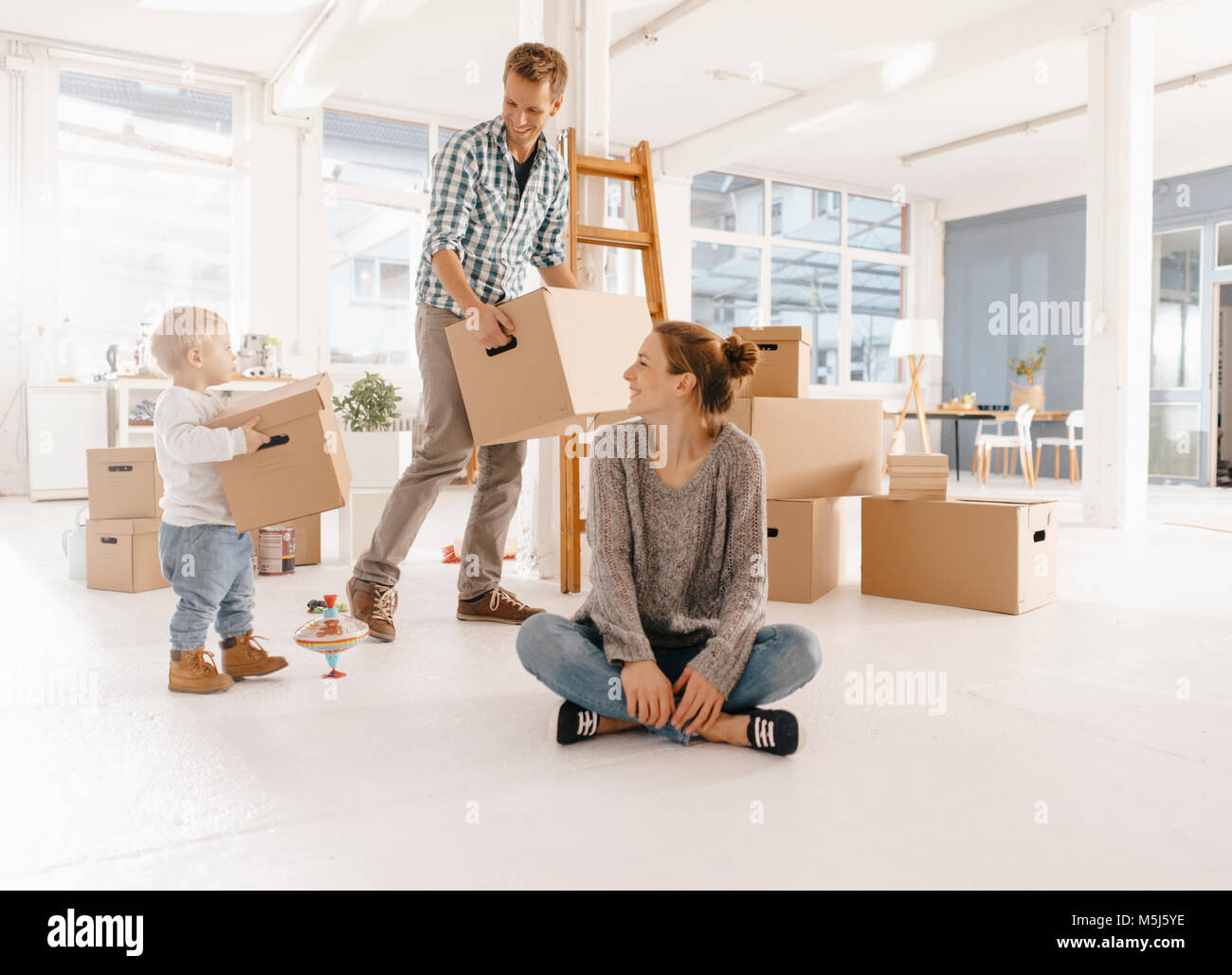 Happy Family déménagement dans la nouvelle maison avec père et fille transportant des boîtes de carton Banque D'Images