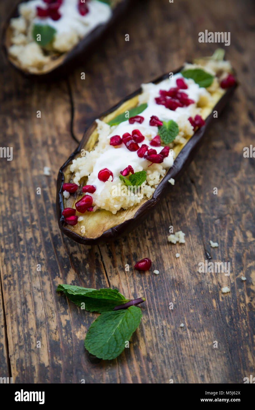 Aubergine rempli, couscous, sauce yogourt, menthe et graines de grenade Banque D'Images