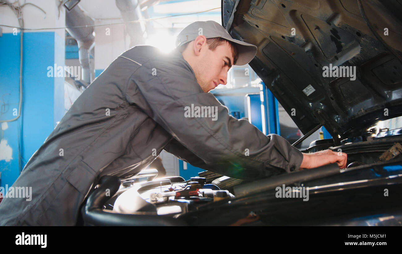 En salopette mécanicien travaillant dans le garage - réparation de SUV de  luxe en face de Sun Photo Stock - Alamy