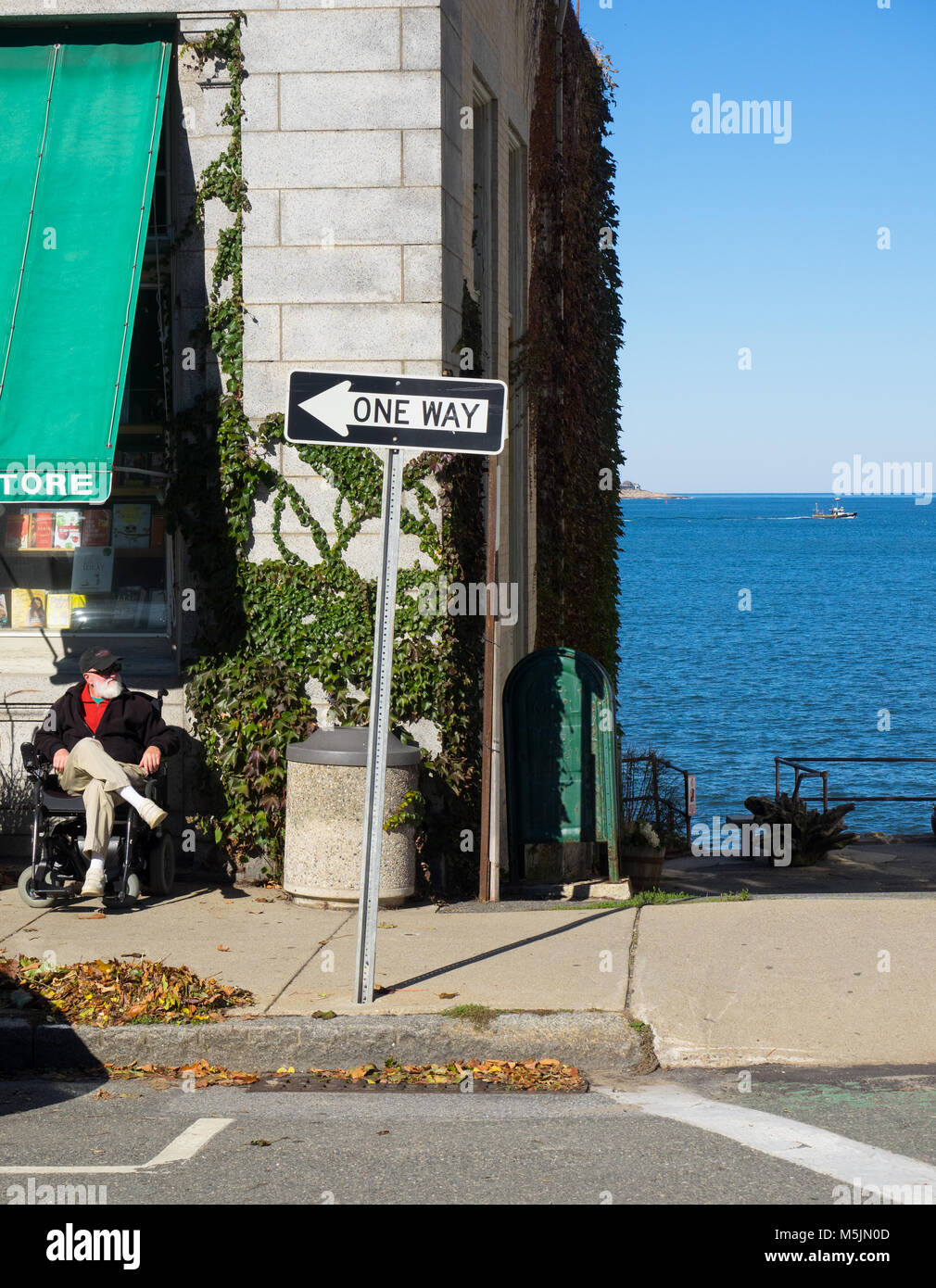 Vieil homme assis dans un fauteuil roulant en profitant du soleil. Banque D'Images