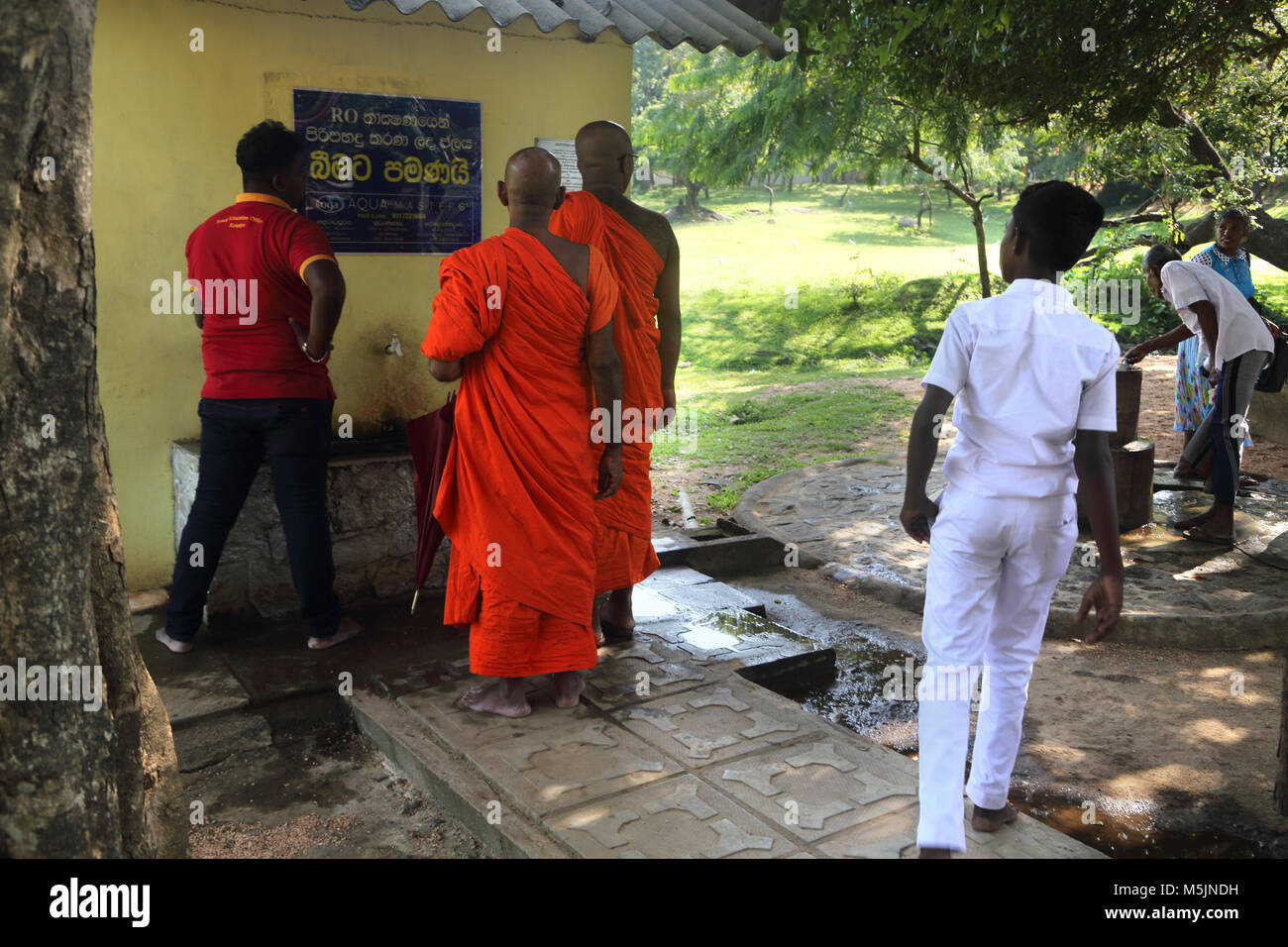 Polonnaruwa North Central Province Sri Lanka des moines bouddhistes la queue pour utiliser la Numérotation automatique Banque D'Images