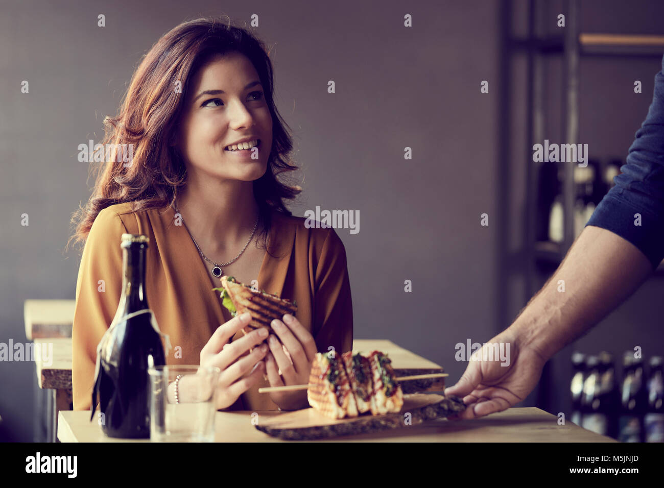 Jolie femme manger un club sandwich Banque D'Images