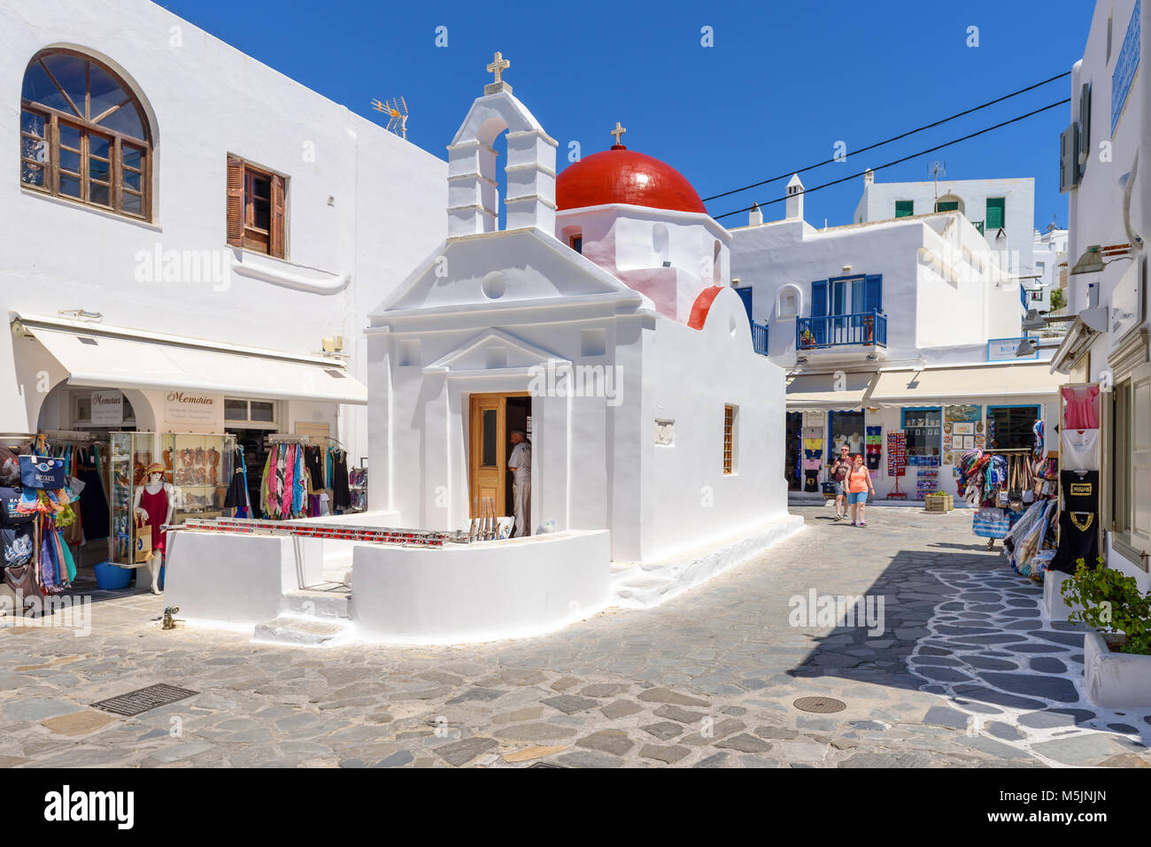 MYKONOS, GRÈCE - 23 mai 2017 : une vue de l'église grecque typique immeuble sur place avec des magasins dans la ville de Mykonos. Cyclades, Grèce Banque D'Images
