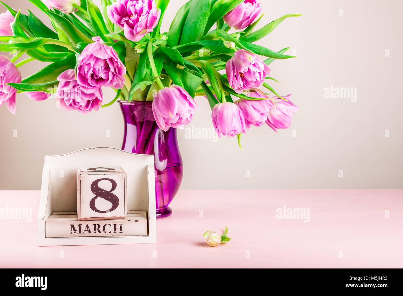 Bloc en bois avec date de la Journée internationale des femmes, le 8 mars, à proximité de tulipes violet Banque D'Images