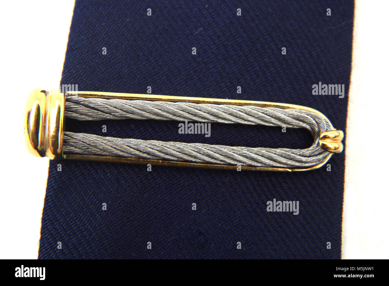 Acier inoxydable, argent et plaqué or Tie Pin Charriol sur cravate bleue Banque D'Images