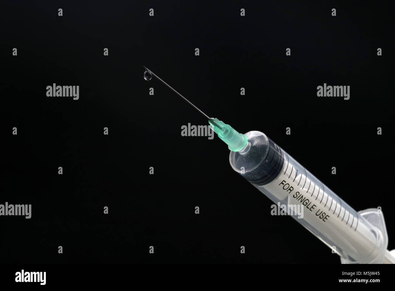 Seringue en plastique close-up avec drop isolated on black Banque D'Images